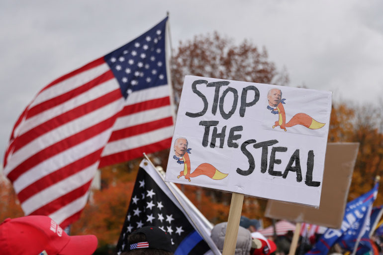 A sign reading "Stop the steal" and the American flag at a protest