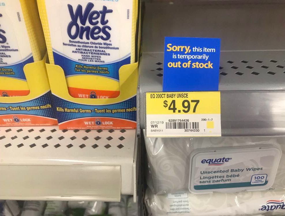 A sign reading "sorry, this item is temporarily out of stock" is in front of an empty store shelf.