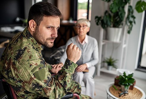 A man dressed in a military uniform sitting with a woman.