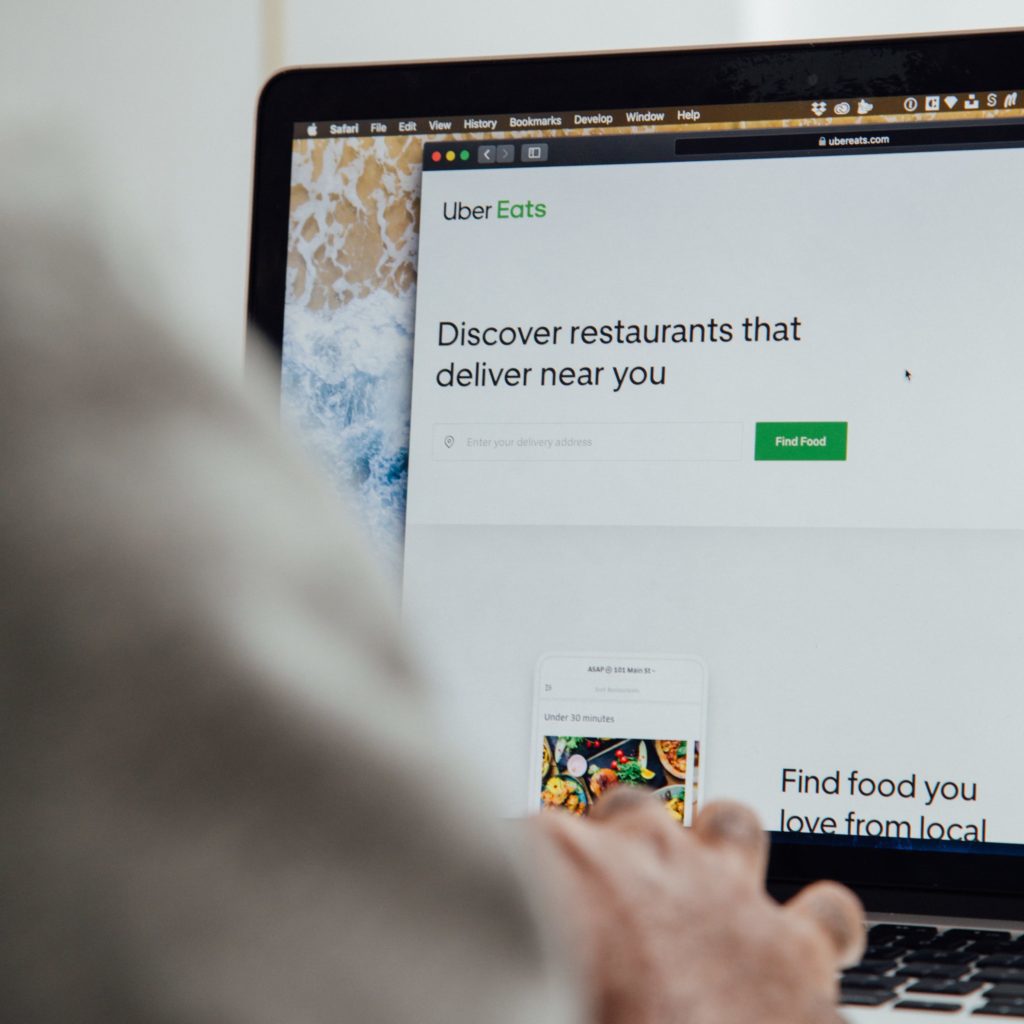 Individual using a laptop with Uber eats app visible on the screen.
