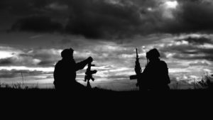 A black and white photo of two soldiers holding their weapons. (Image by Daniel Hadman from Pixabay)