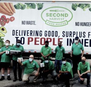 A group of people posing in front of a truck.