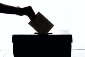 Shadow of a ballot box and a hand putting in a ballot.