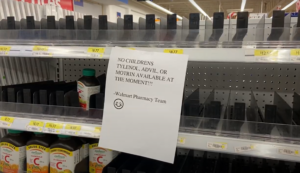 White sign posted on shelf at Walmart.