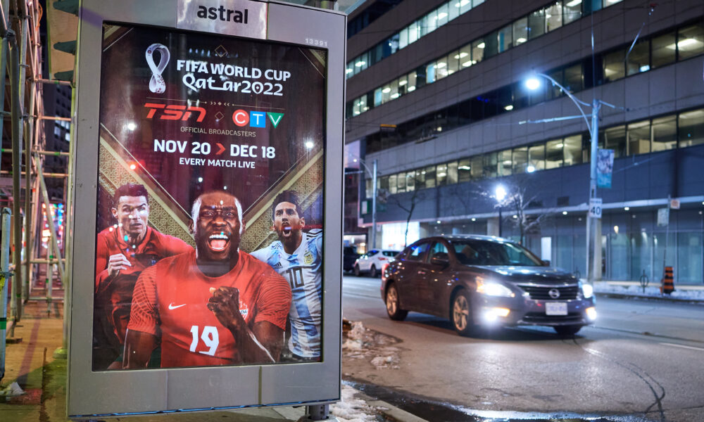 car drives by street advertisement of soccer tournament