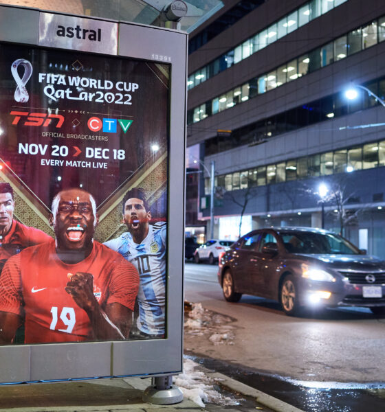 car drives by street advertisement of soccer tournament