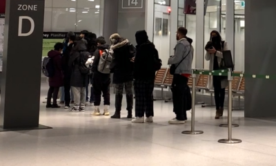 People lined up at a GO bus station gate