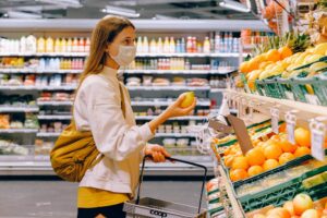 Woman holding fruit while grocery shopping. (PEXELS/Anna Shvets)